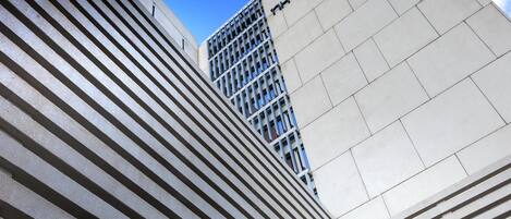 Un edificio moderno con un llamativo letrero 'NH Collection' y un logotipo en la fachada.