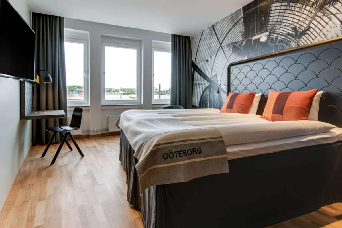 Una habitación de hotel con cama, escritorio y silla.