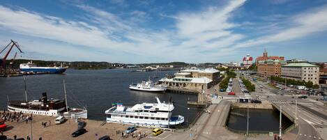 A harbor with boats, a large building with a dome, and a road leading to a bridge.