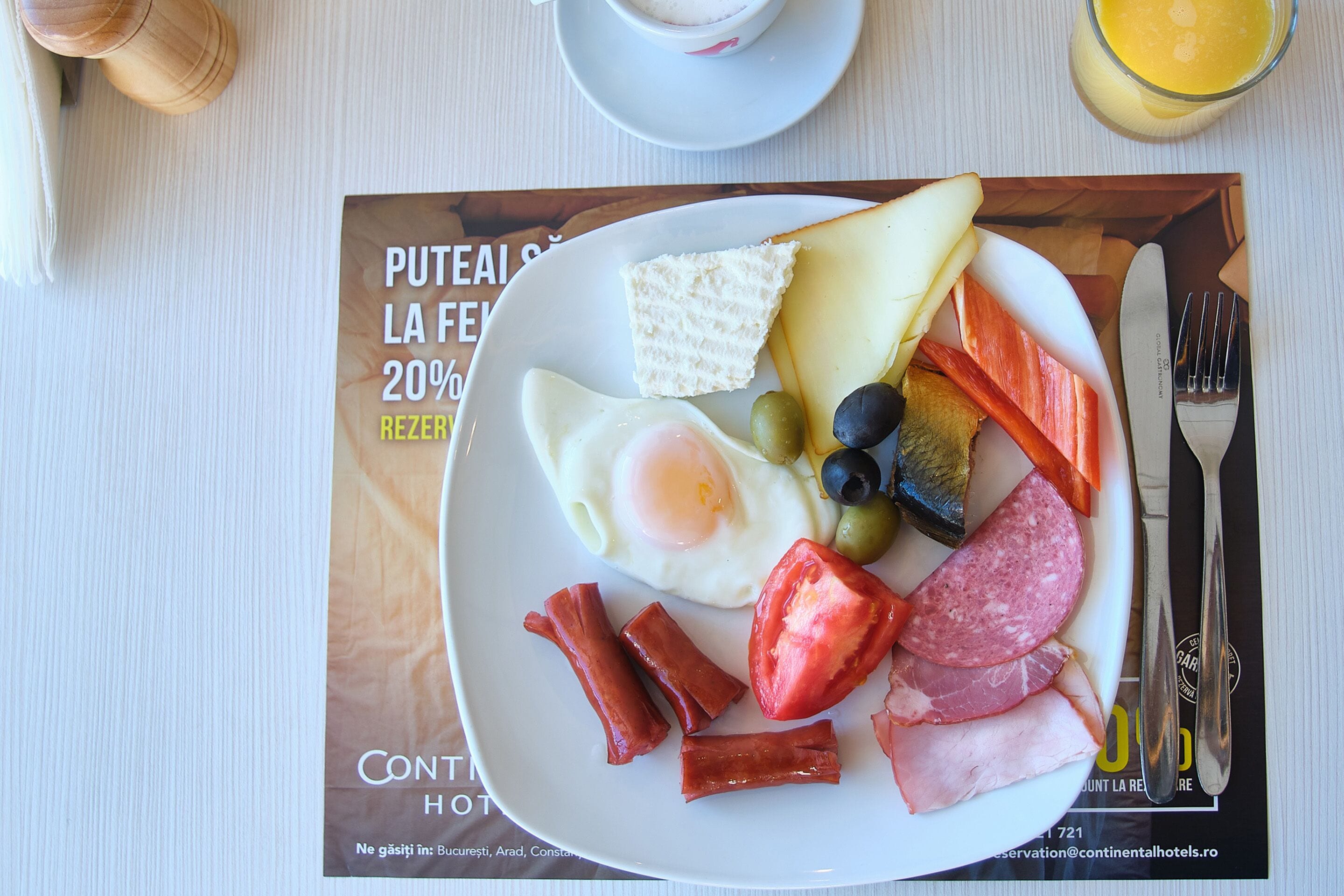 En morgenmads tallerken med æg, skinke, ost og grøntsager.