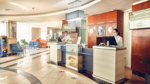 A hotel reception area with a modern design, featuring a reception desk, a digital clock, and a signboard with room names. - Continental Forum Constanta (Constanta)
