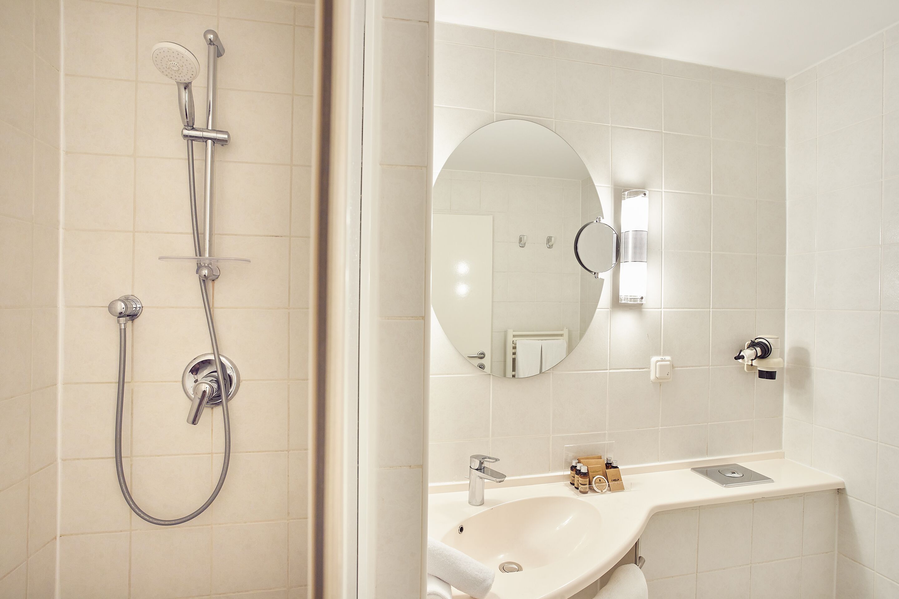 A bathroom with a shower, sink, and mirror.