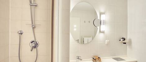 A bathroom with a shower, sink, and mirror.