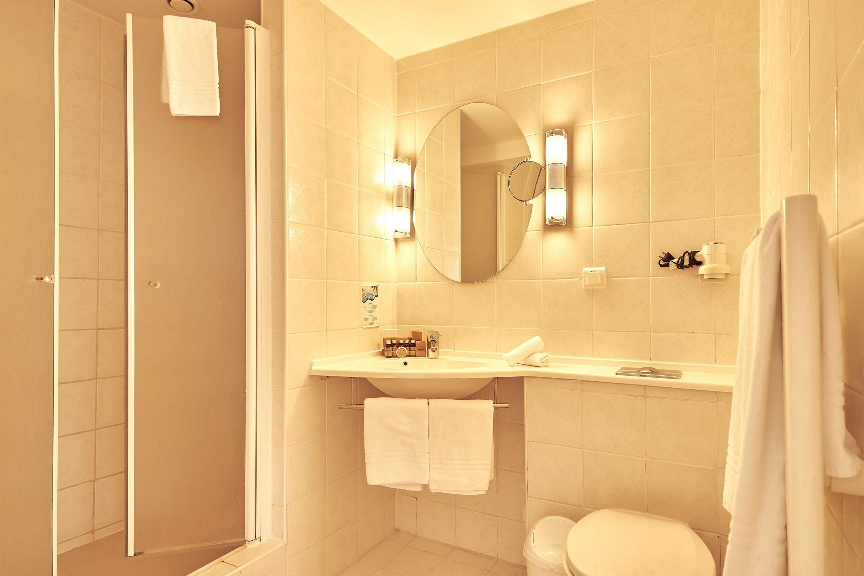 Un baño con ducha, inodoro, lavabo y espejo.