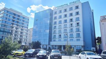 A multi-story hotel with a modern glass facade and the name "Continental Forum" on the top.
