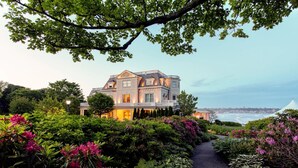 A large, elegant house with a well-maintained garden and a view of the sea. - The Chanler at Cliff Walk (Newport)