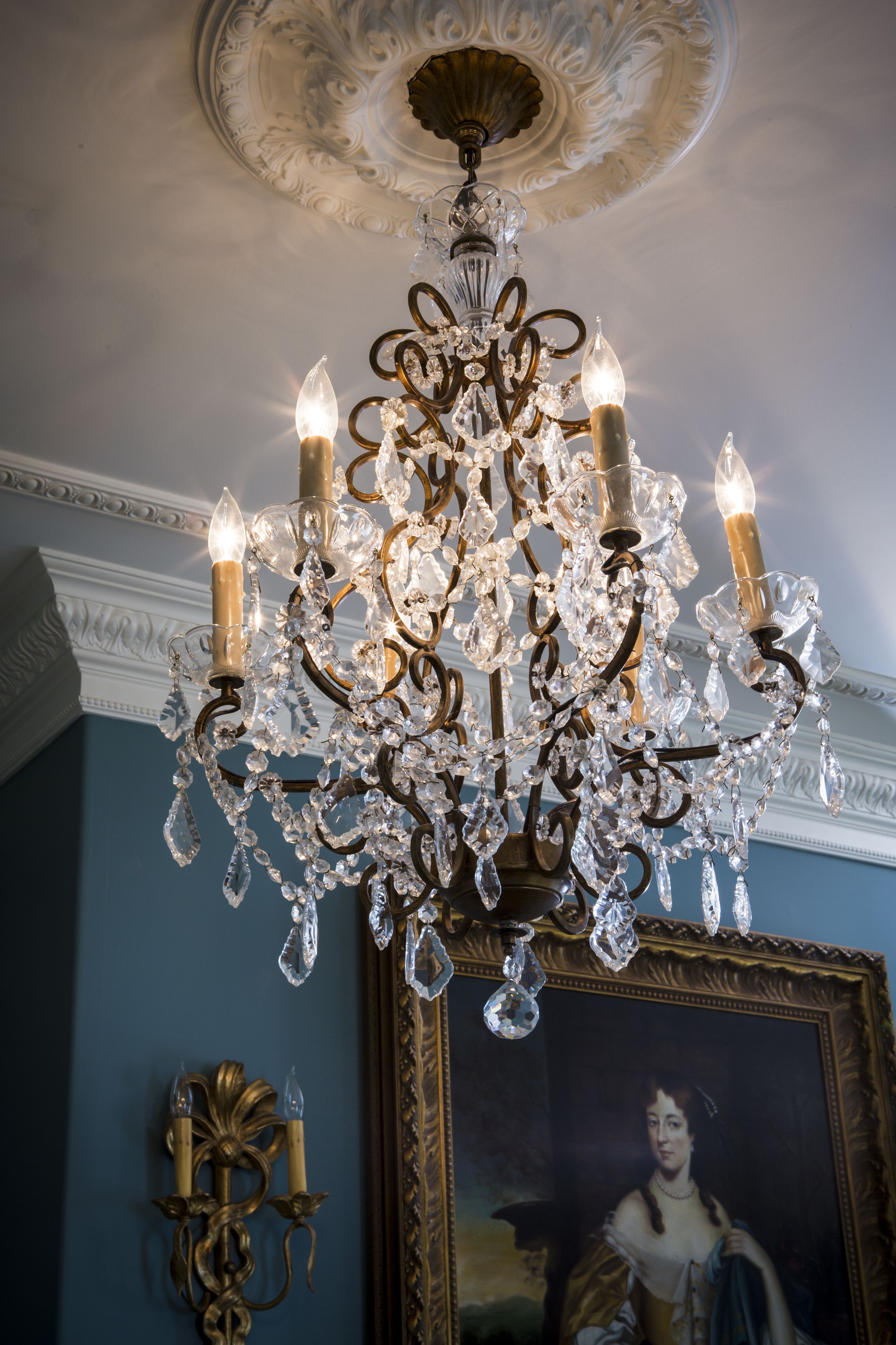 Een kroonluchter met meerdere lampen en kristallen decoraties.