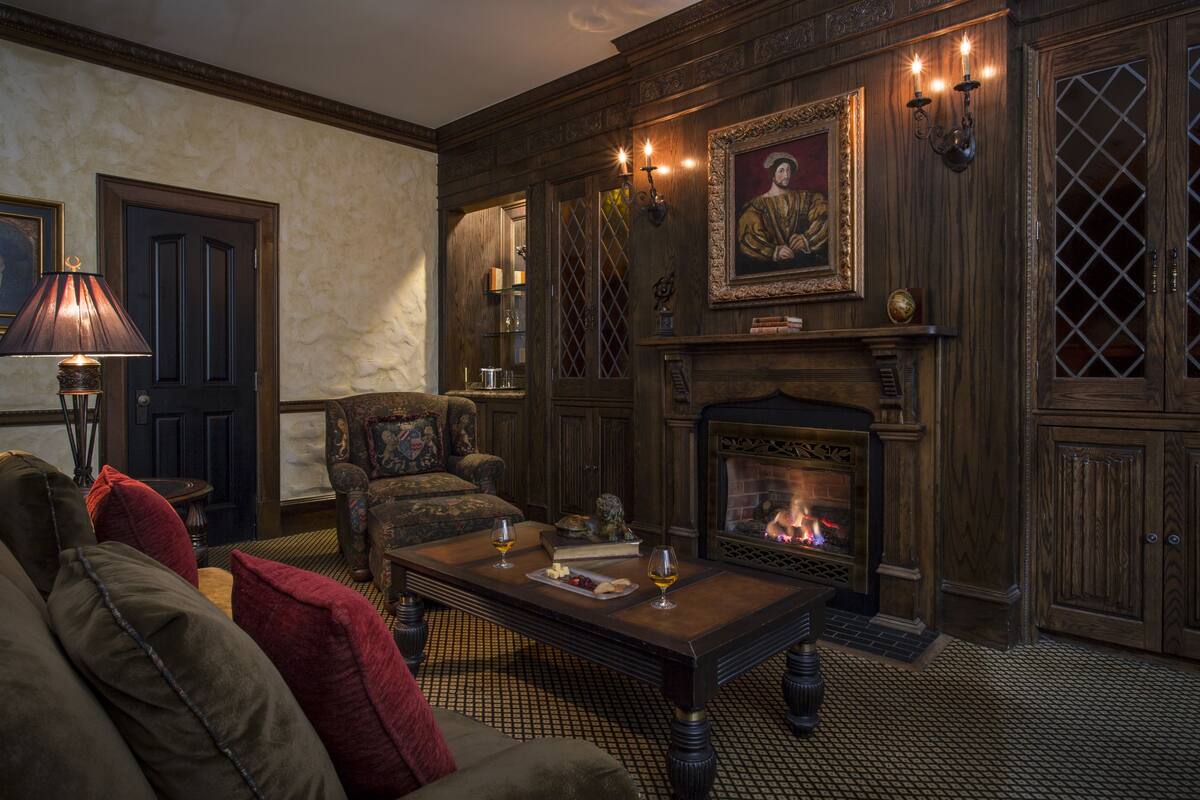 A cozy living room with a fireplace, comfortable seating, and a decorative wall.