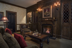 A cozy living room with a fireplace, comfortable seating, and a decorative wall. - The Chanler at Cliff Walk (Newport)