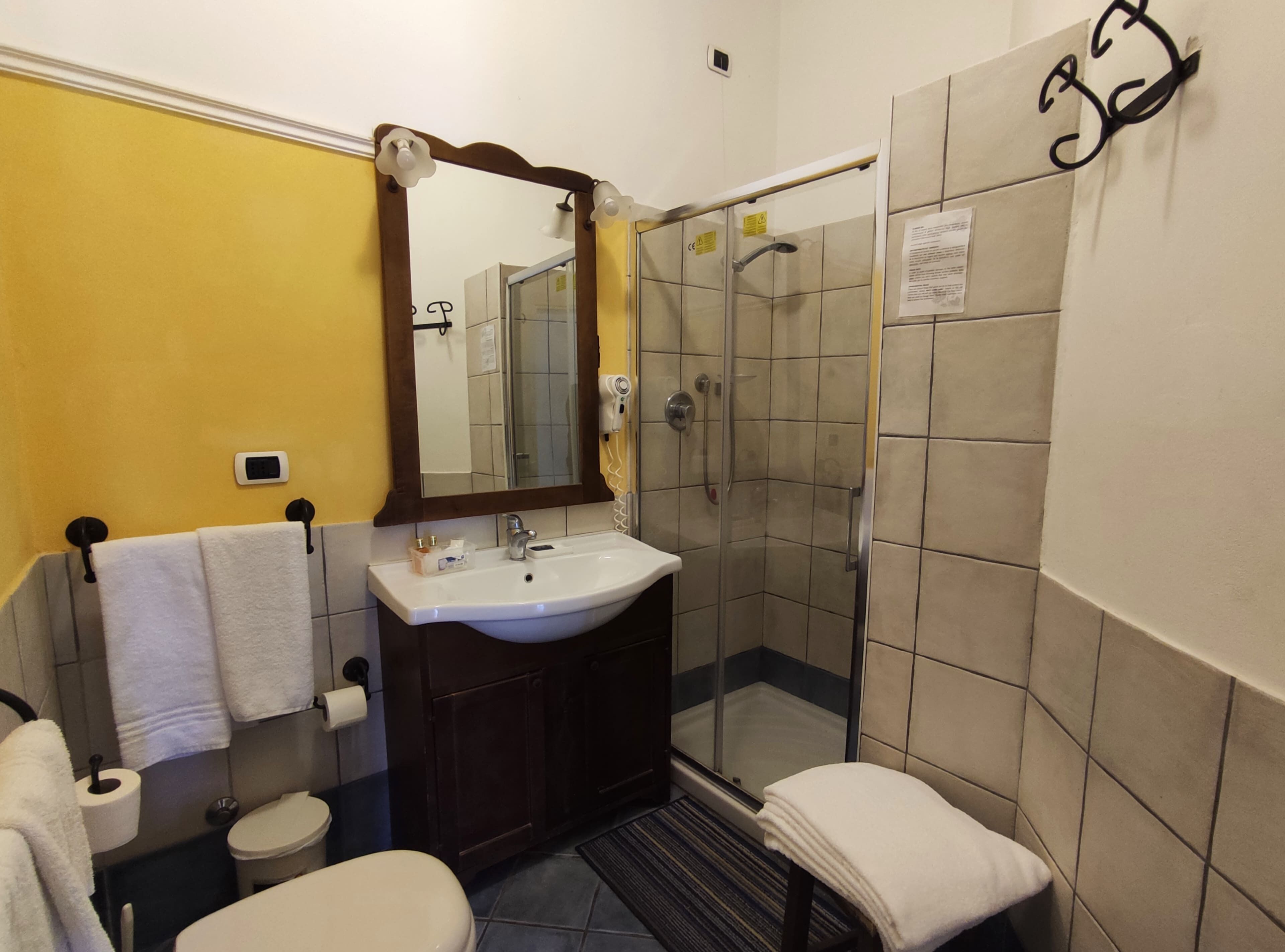 Kylpyhuone, jossa on pesuallas, peili, wc ja suihku.