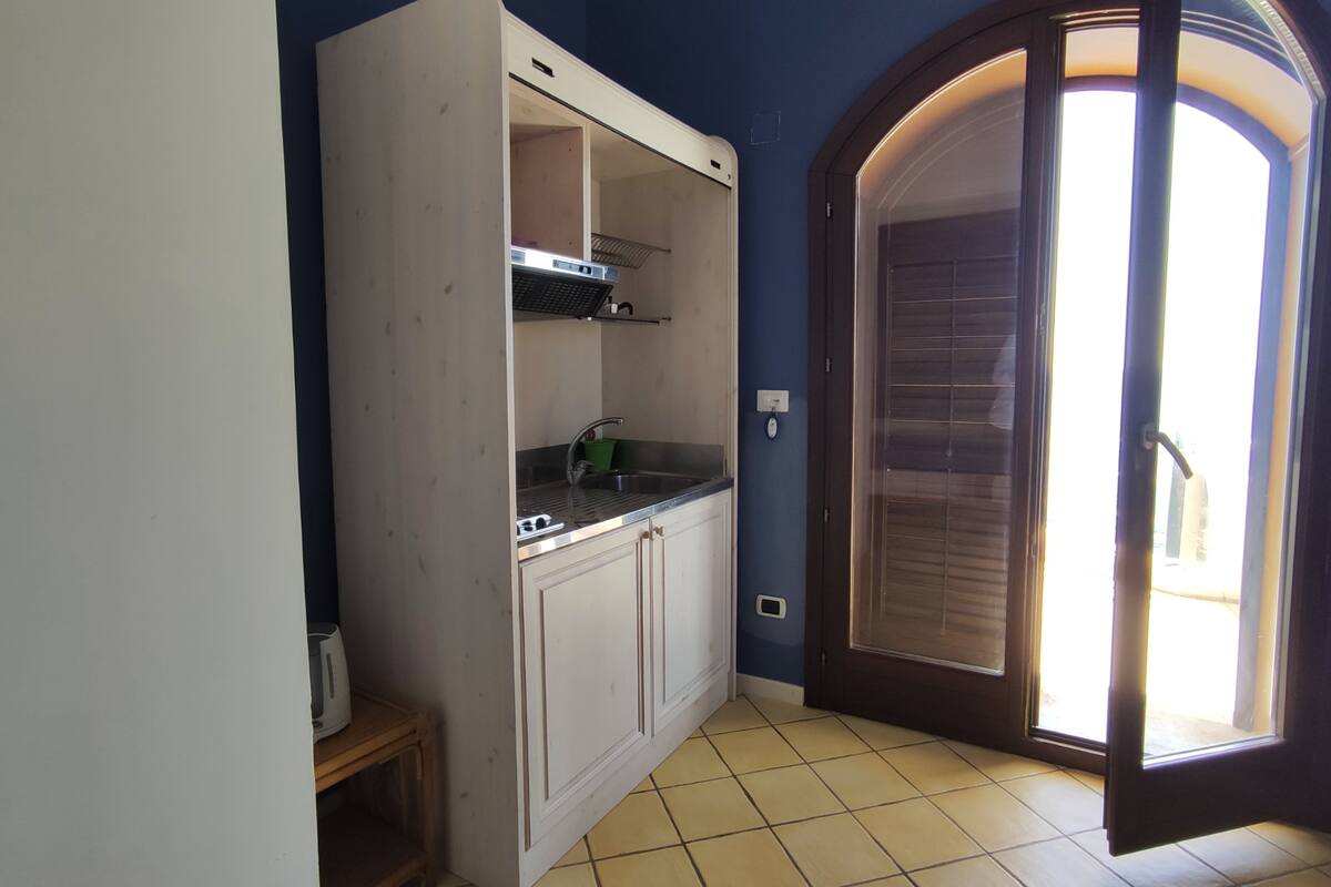 A kitchen with white cabinets, a countertop, and a window.