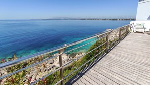 A wooden deck with a railing overlooking a clear blue sea. - La Rosa sul Mare (Syracuse)