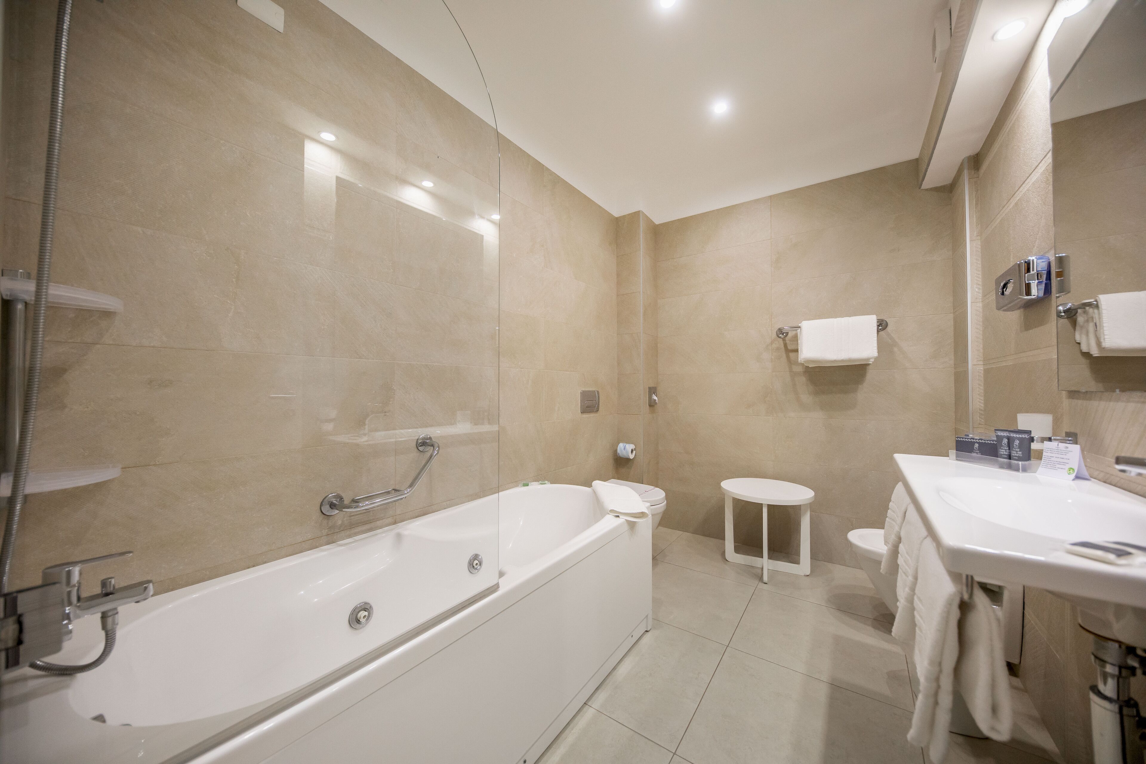 Une salle de bain moderne avec une grande baignoire, des toilettes et un lavabo.