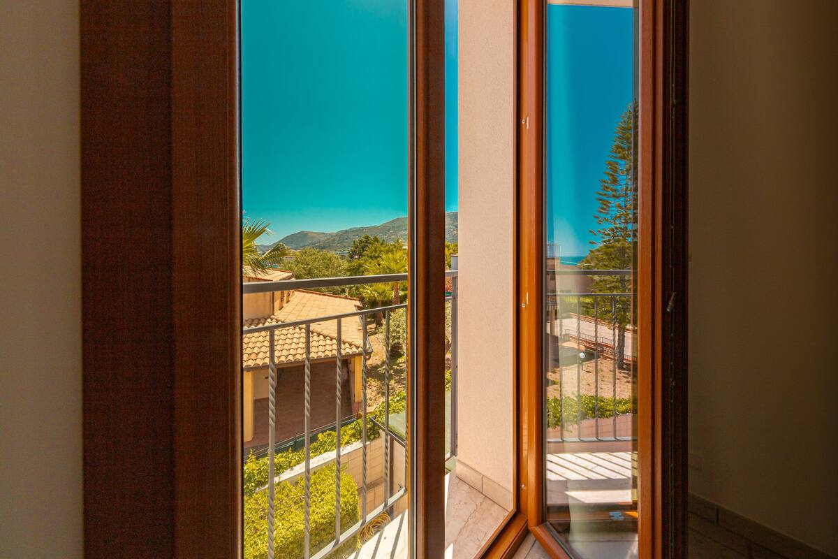 Un balcon offrant une vue sur un paysage montagneux et un ciel bleu dégagé.