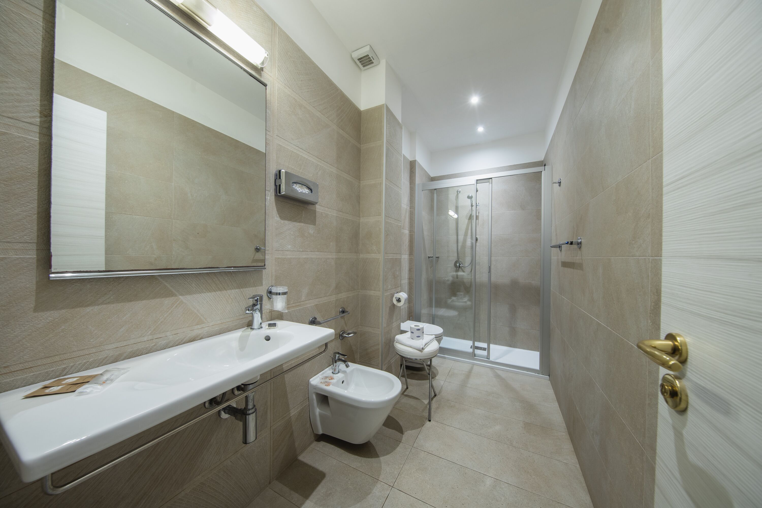 Un baño moderno con un lavamanos grande, un bidé y un inodoro separado.