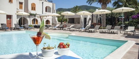 Piscine extérieure, parasols de plage, chaises longues