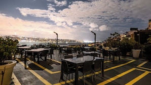 An outdoor dining area with tables and chairs, overlooking a cityscape and body of water. - Grand Star Hotel Bosphorus & Spa (Istanbul)