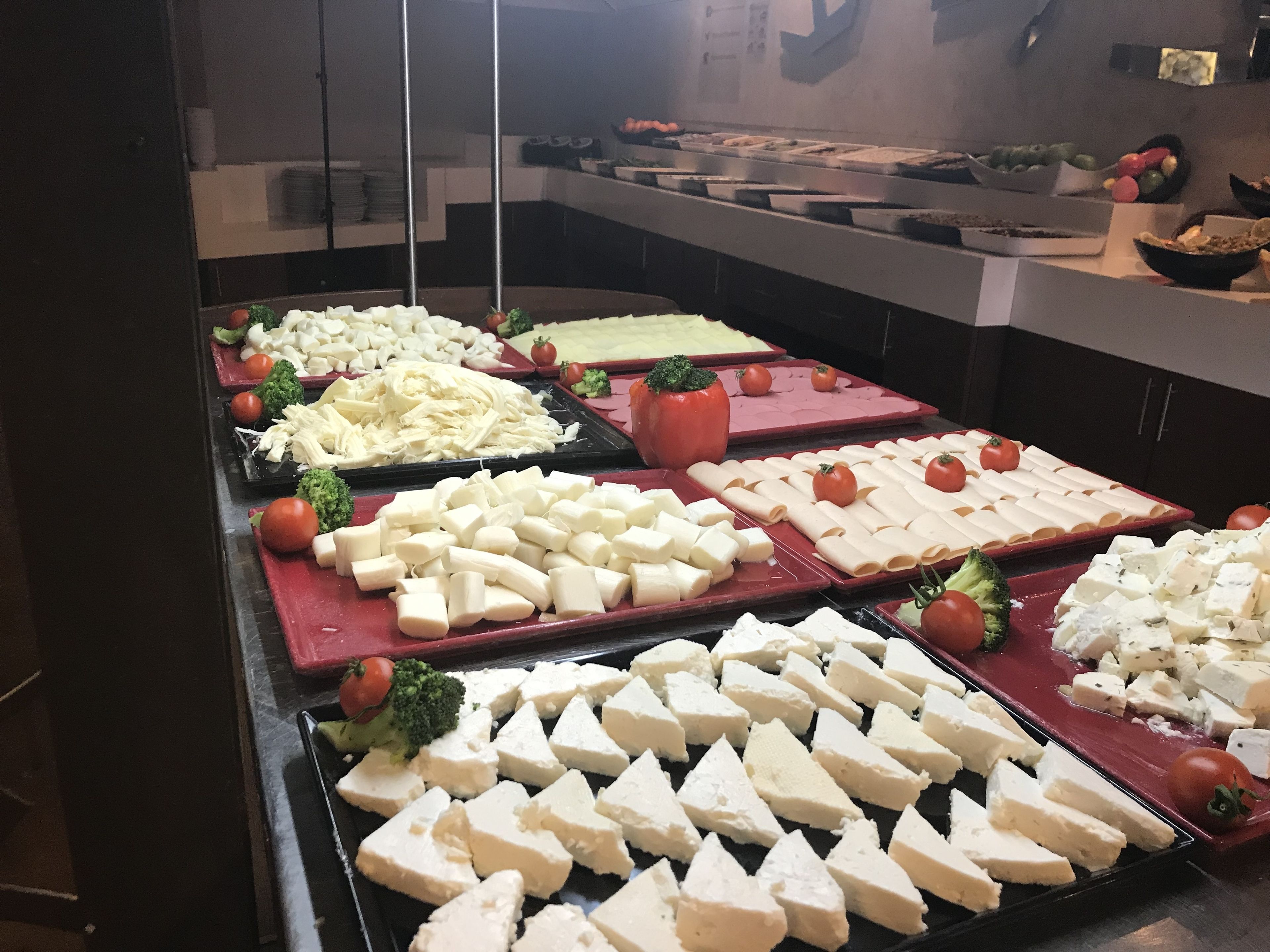 Un bufé con diferentes opciones de comida, como queso, verduras y frutas.
