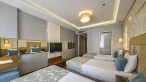 A hotel room with two beds, a TV, a mirror, and a small desk with a lamp. - Grand Star Hotel Bosphorus & Spa (Istanbul)