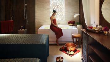 Bathroom features a large bathtub, glass-enclosed shower, and vanity area with mirror and toiletries.