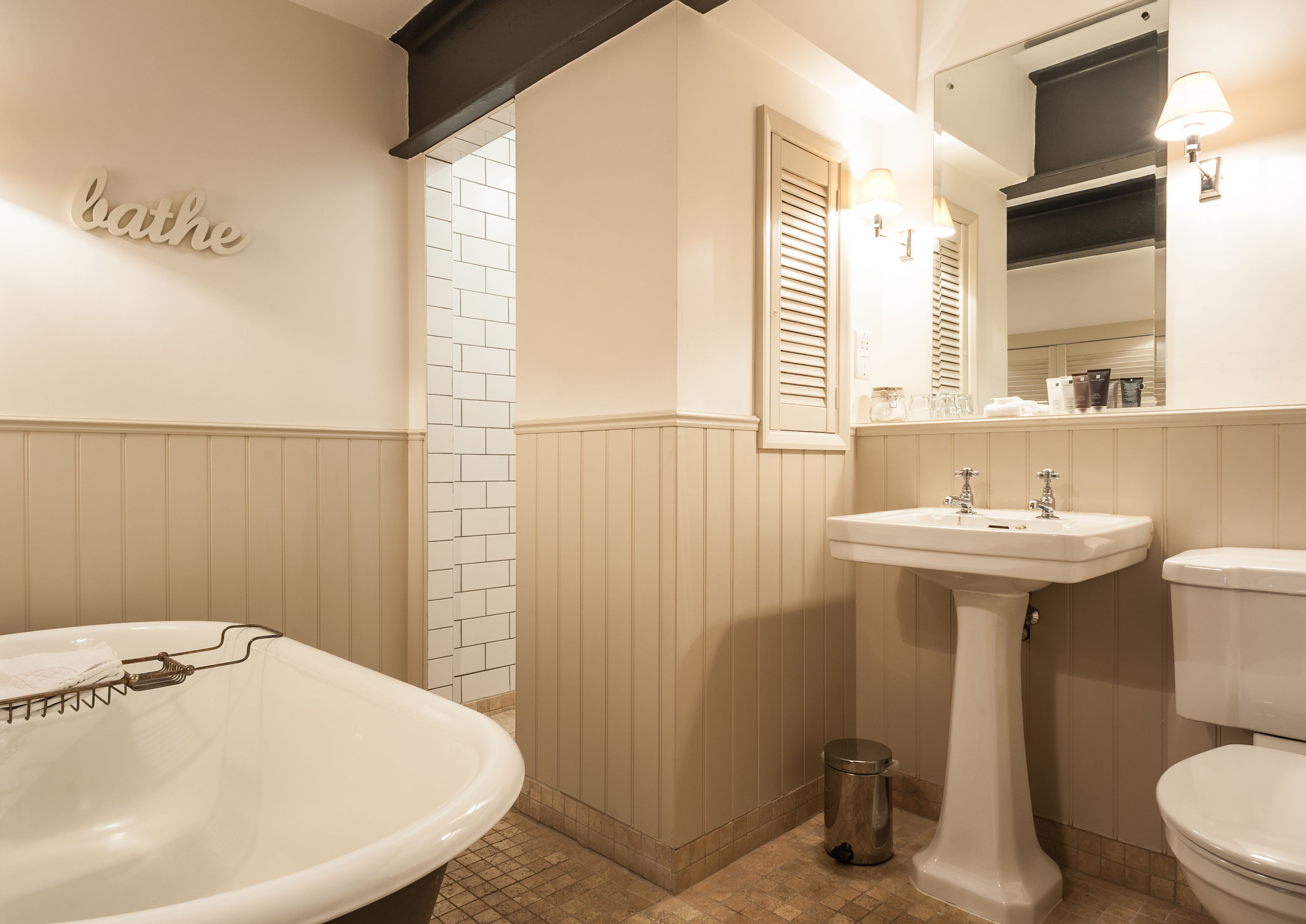 luxe junior suite | bathroom | combined shower/bathtub, rainfall showerhead, designer toiletries