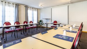 A conference room with tables, chairs, name tags, and a projector screen.
