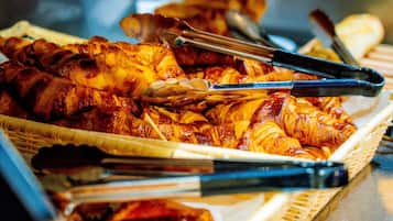 A basket of food items including grilled meat and pastries.