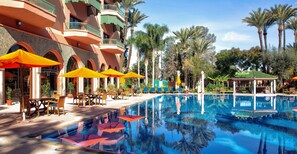 Un espace piscine d’hôtel avec des sièges en plein air et un bassin décoratif.