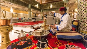 A traditional interior with ornate decor, a central table with silverware, and a patterned carpet. - Royal Mirage Deluxe Marrakech (Marrakech)