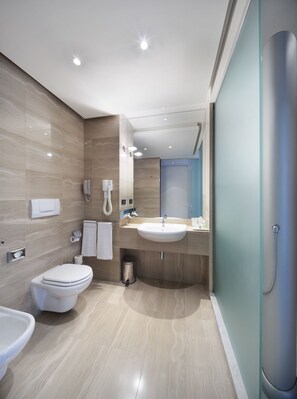 A modern bathroom with a toilet, bidet, and sink. - DoubleTree by Hilton Turin Lingotto (Turin)