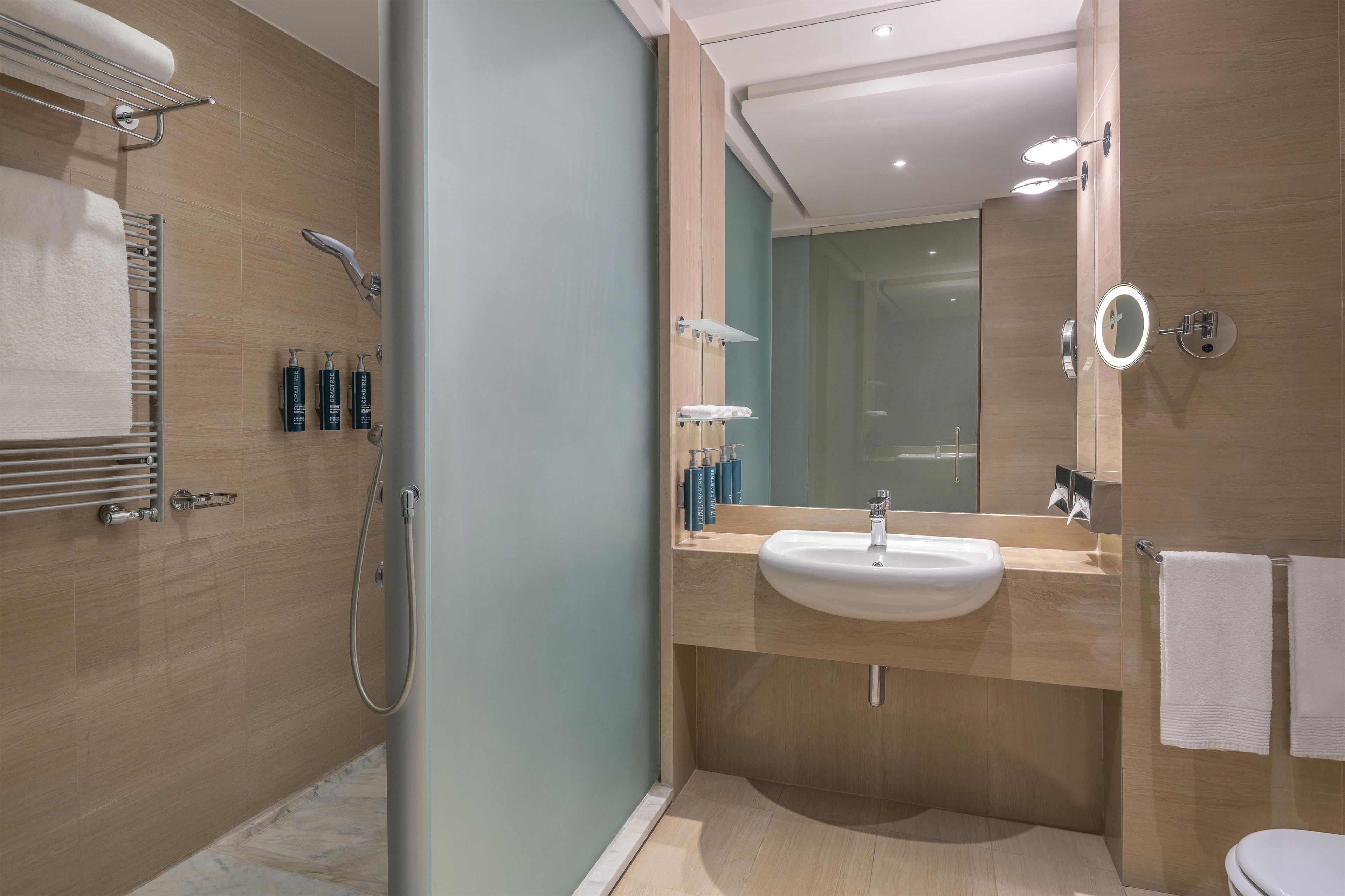 Un bagno moderno con doccia, lavandino e WC.