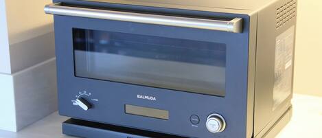 A kitchen appliance with a digital display, control panel, and ventilation grill.