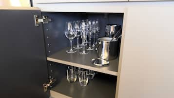A cabinet with multiple wine glasses and a metal container.