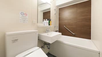A bathroom with a toilet, sink, and bathtub. There is a mirror above the sink and a wooden door to the right.