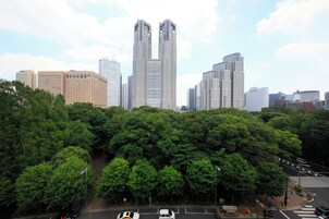 A cityscape with modern high-rise buildings and dense green trees.