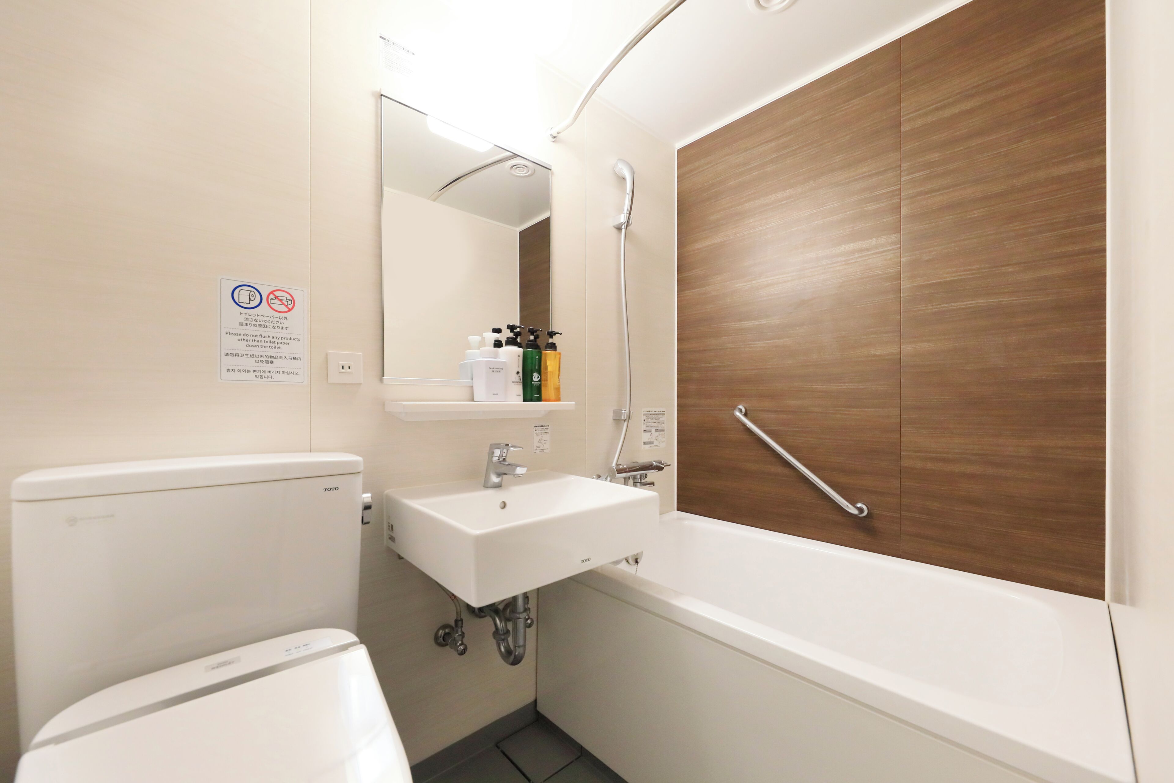 Un baño pequeño y moderno con inodoro, lavamanos y ducha.