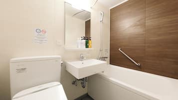 A bathroom with a toilet, sink, and bathtub. There is a mirror above the sink and a wooden panel on the wall.
