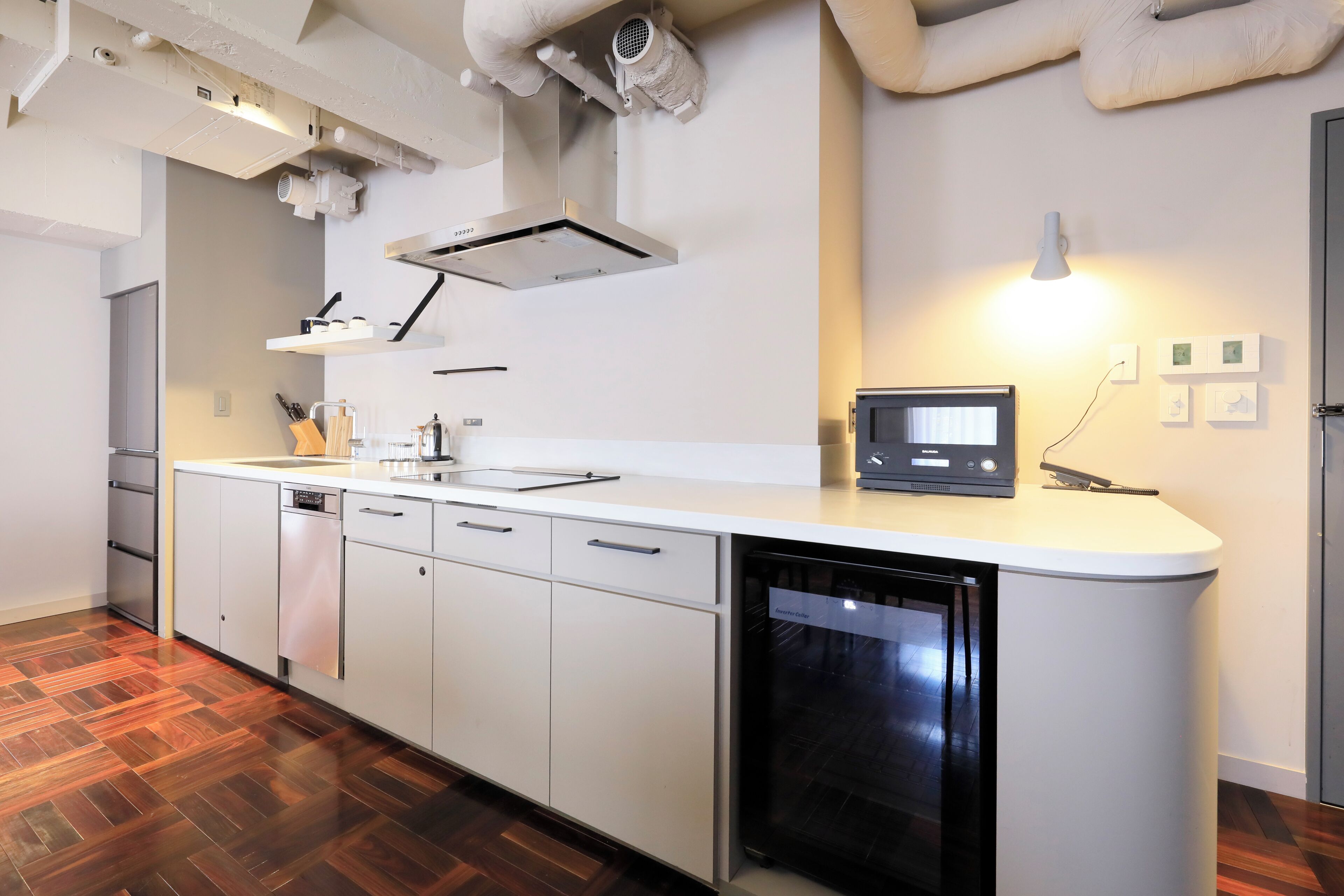 Une cuisine moderne avec des meubles blancs, un lave-vaisselle et un four à micro-ondes.