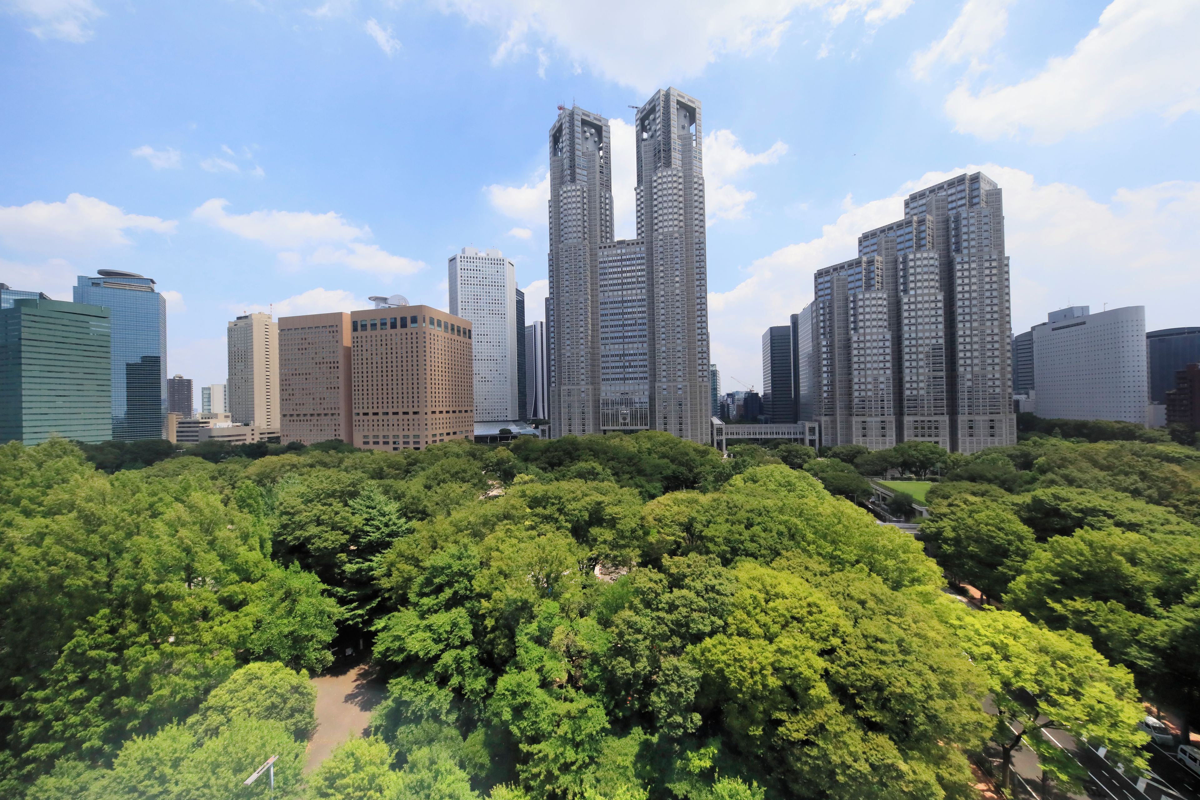 Un paisaje urbano con modernos edificios altos y una extensa área verde con parque.