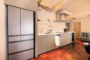 Una cocina moderna con lavavajillas incorporado, electrodomésticos de acero inoxidable y piso de madera.
