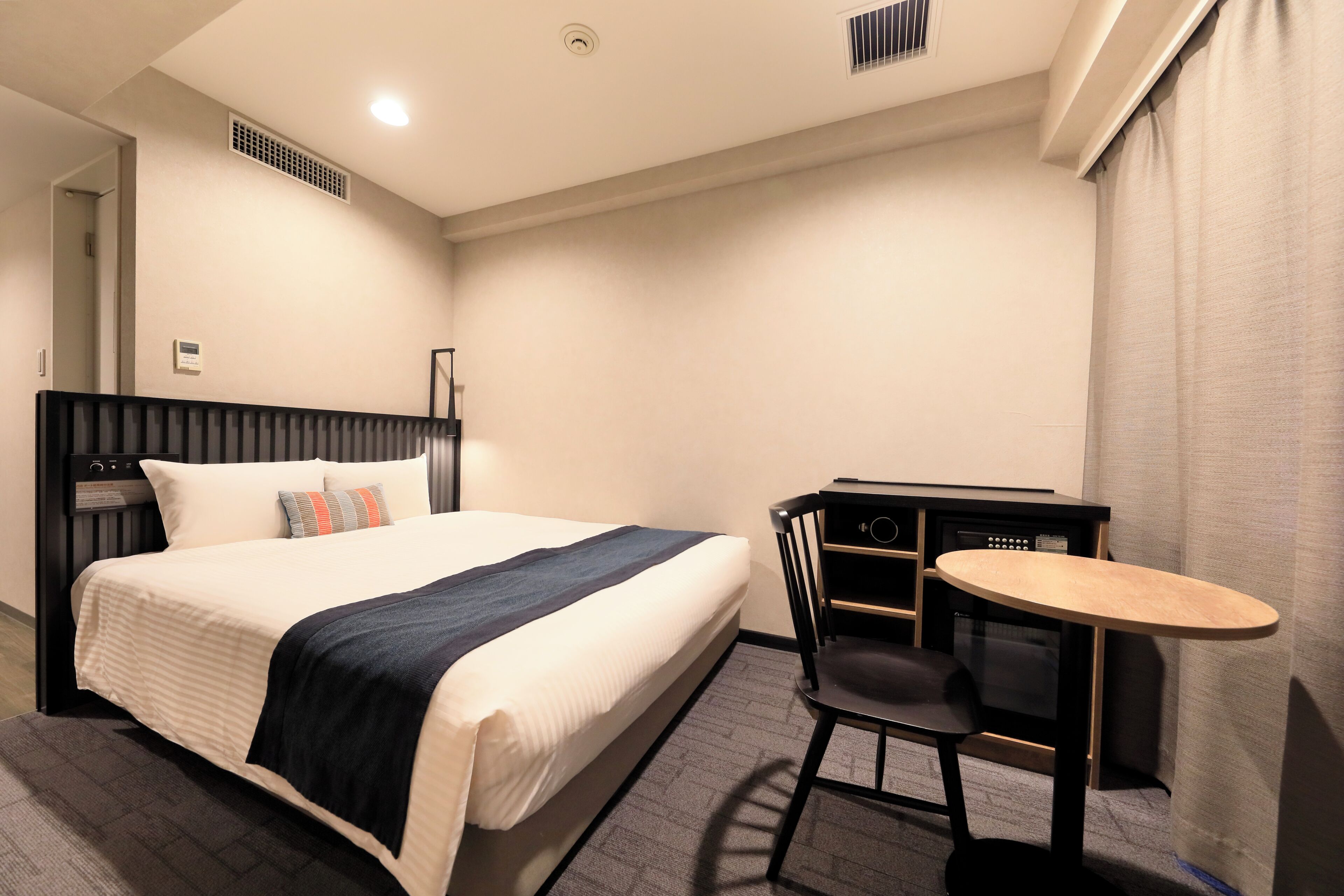 Una habitación de hotel con cama, escritorio y silla.