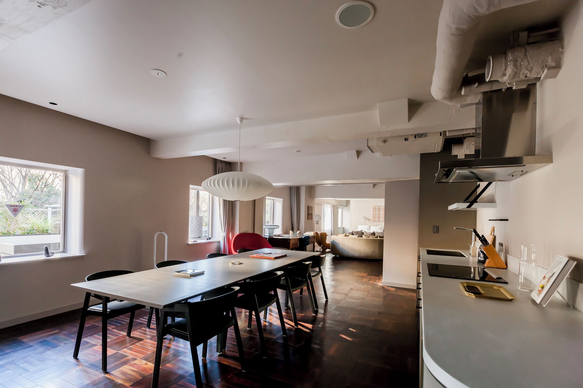 Una cocina moderna con comedor, piso de madera y un ventanal grande.