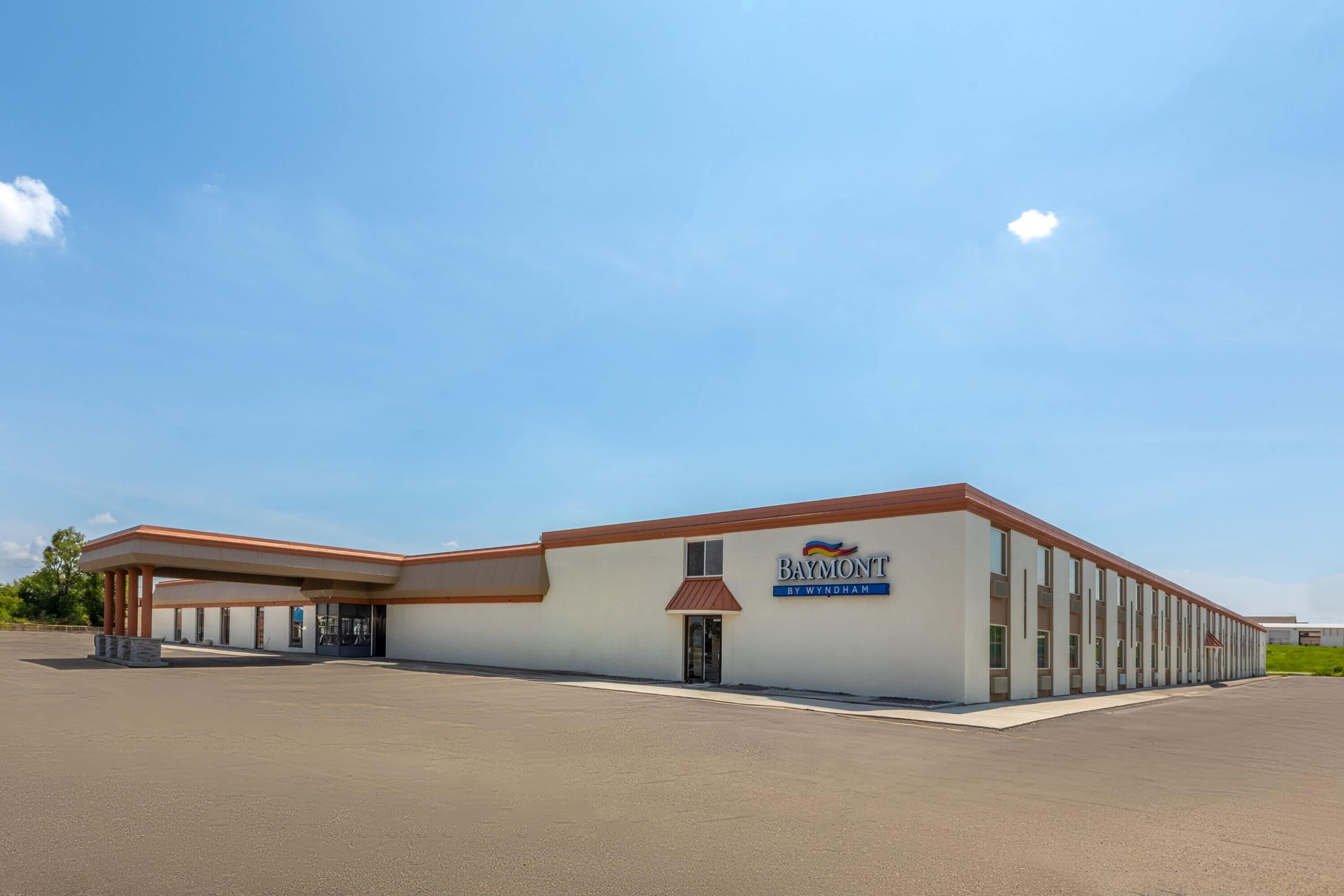 A Baymont by Wyndham hotel with a single-story structure, a covered entrance, and a parking lot.