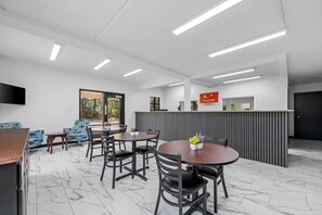 A modern reception area with a counter, seating for guests, and a television. - Econo Lodge Inn & Suites Lugoff (Lugoff)