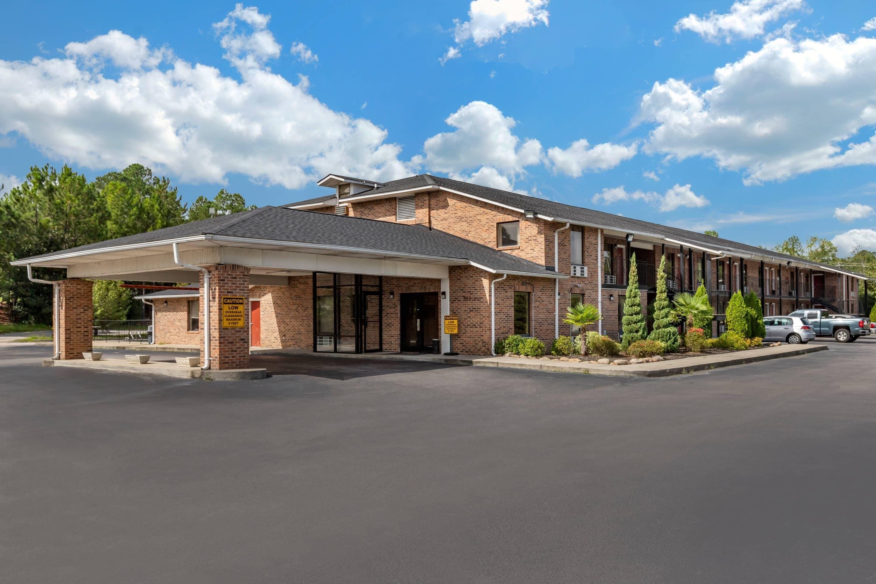 A two-story motel with a covered entrance and a parking lot.