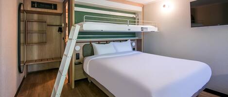 A bunk bed with a wooden ladder, a small shelf, and a television on the wall.