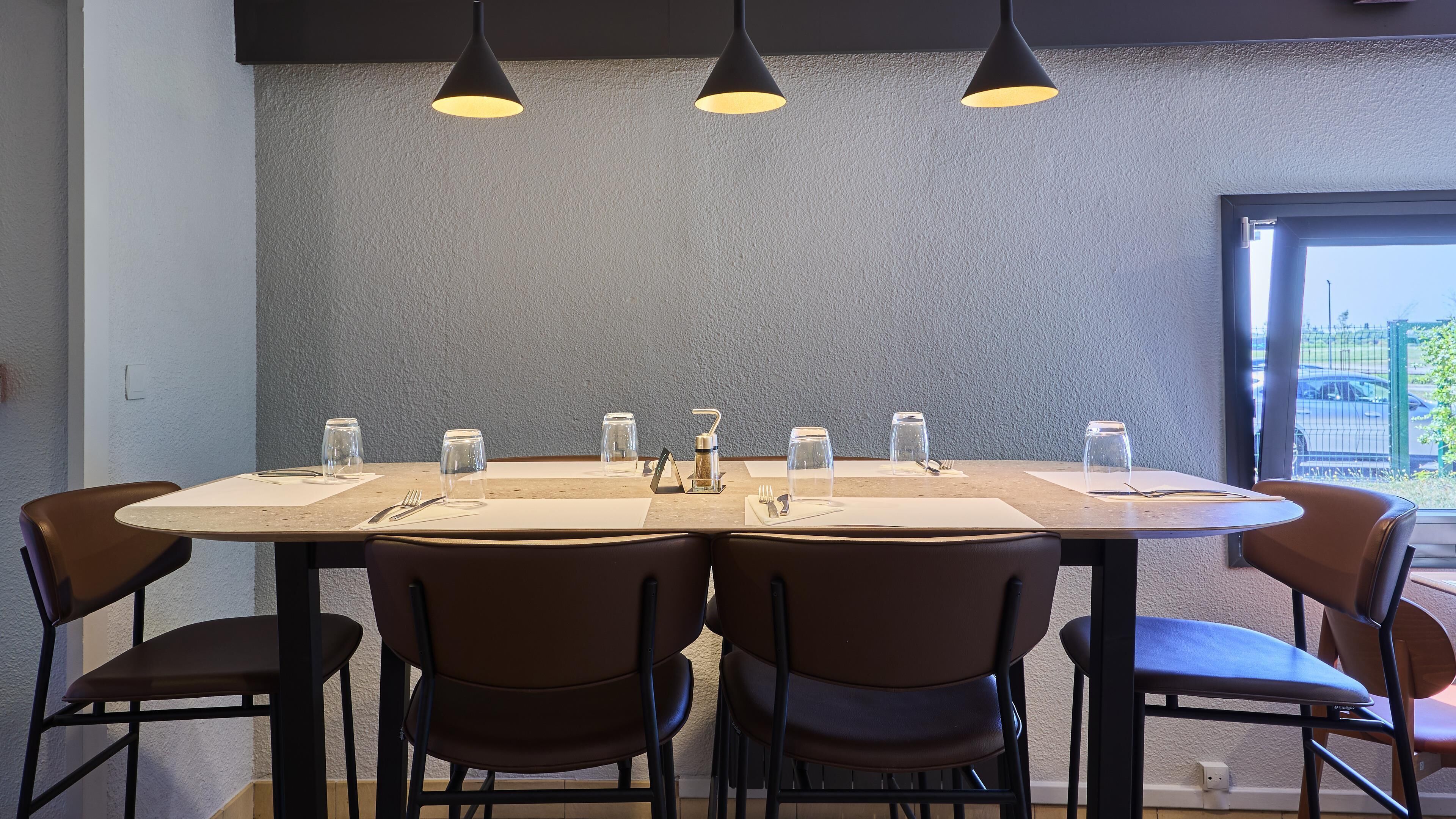 A conference table with chairs, a water dispenser, and glassware set for a meeting.