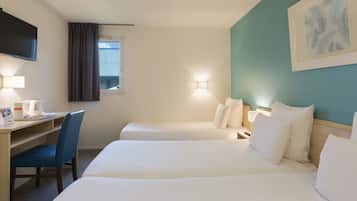 A hotel room with two beds, a desk, a chair, a flat-screen TV, and a window with curtains.