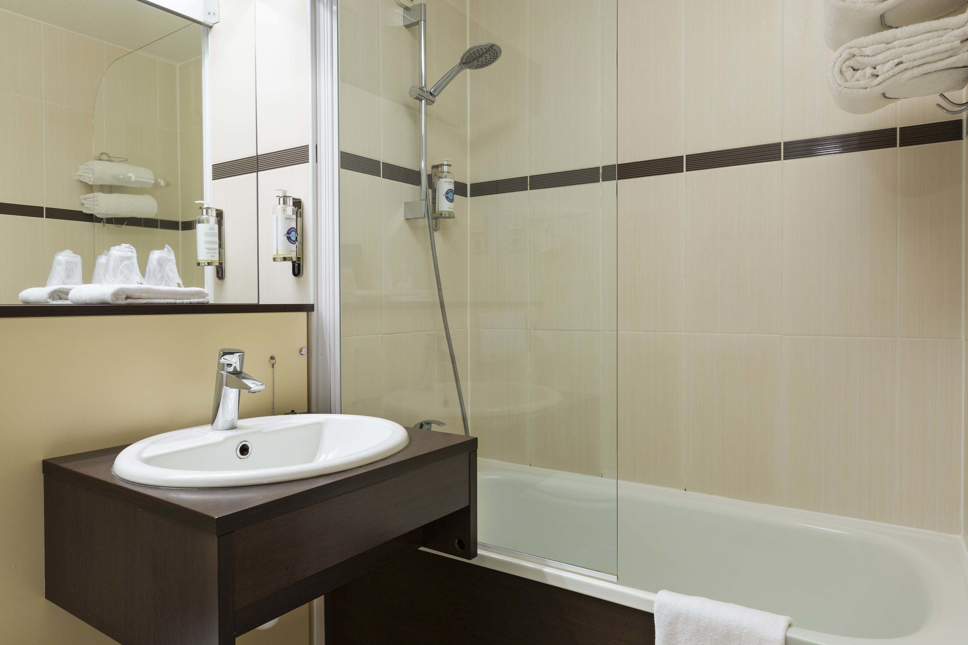 Un baño con lavabo, espejo y ducha.