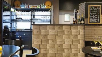 A restaurant interior with a bar area, wine bottles, and a menu board.